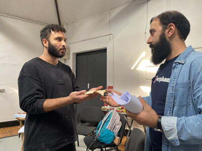 two bearded men holding bread