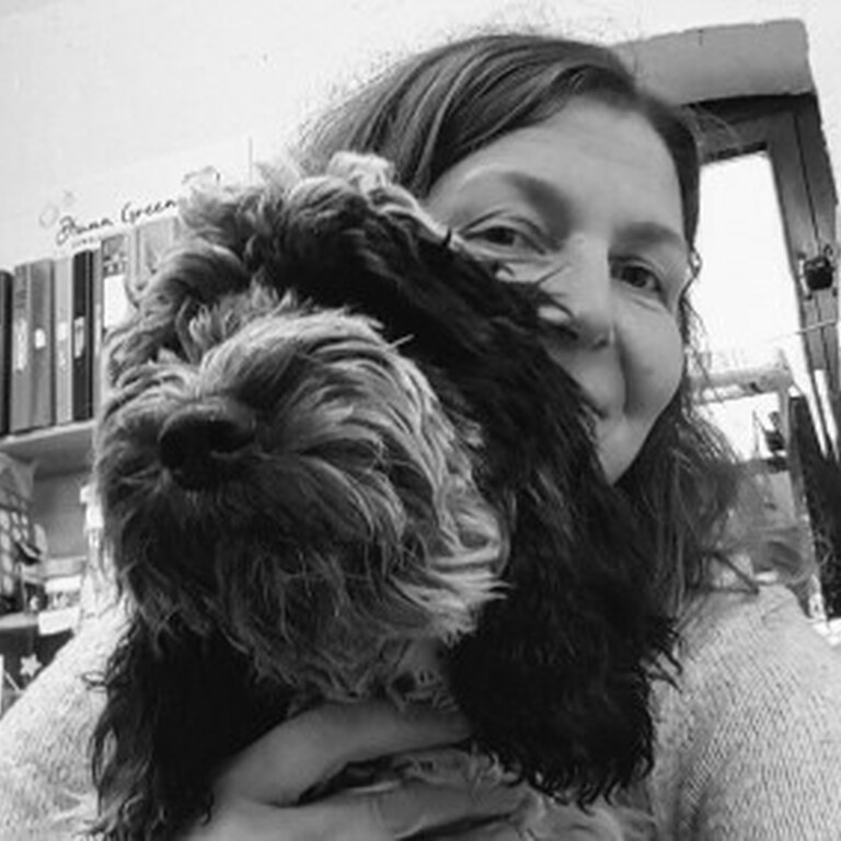 A black and white photo graph of Diana Greenwood and her dog in a studio