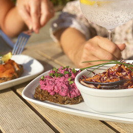 Close up of people of eating and drinking outside the Riverside Cafe