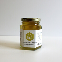 A glass jar of honey on a white table