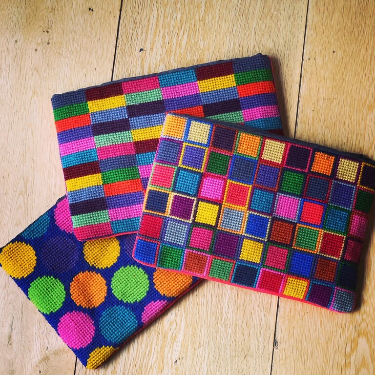 Three brightly coloured hand stitched wallets with circles, squares and oblongs