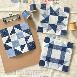Three minature quilt designs on a craft table