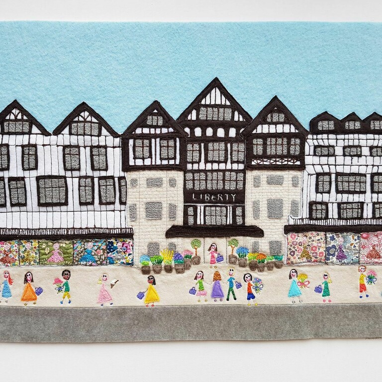 A textile art work of an old fashioned building on a high street