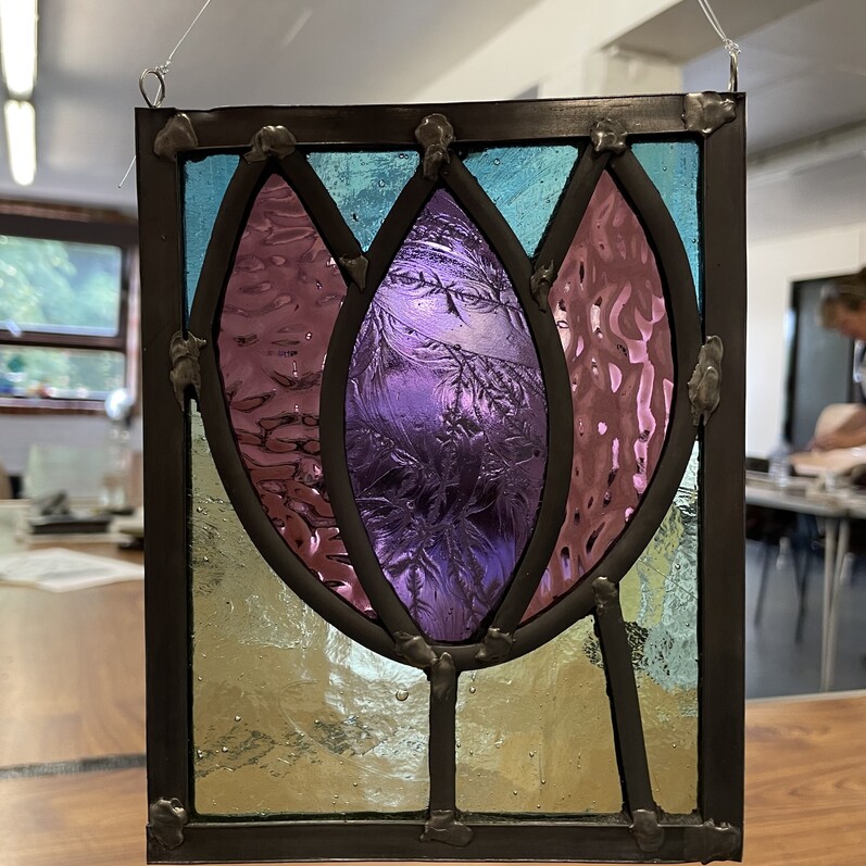 A stained glass leaf design from a stained glass workshop.