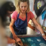 Helen locke assisting a woman with screen printing