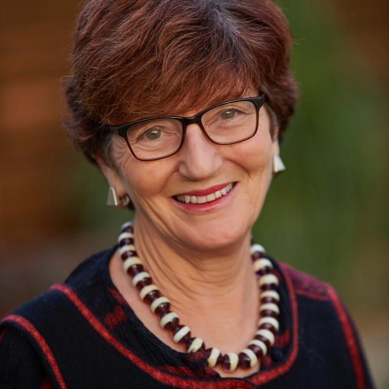lady with short dark hair wearing glasses and a necklace