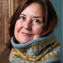 lady with dark hair wearing a blue and yellow scarf