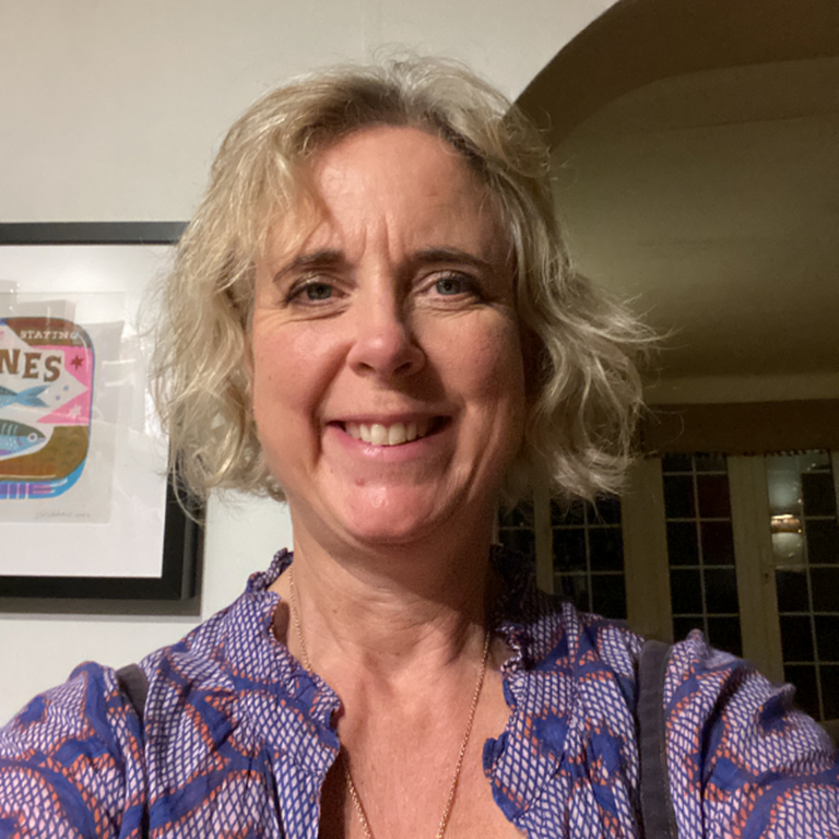 A head shot of Alison Butler wearing a scarf and jumper.