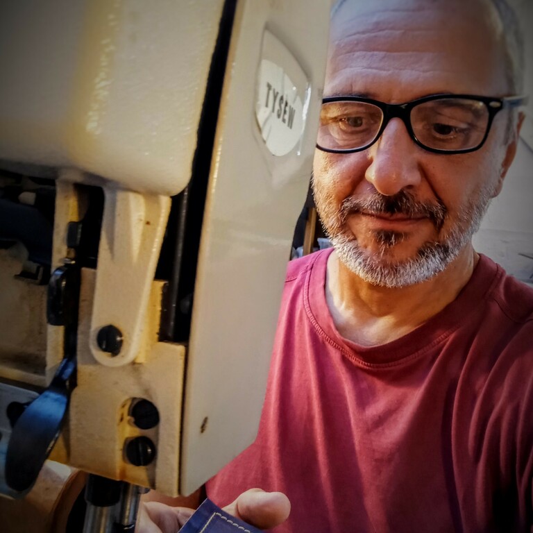 Tibor Eperjessy feeding fabric through a sewing machine