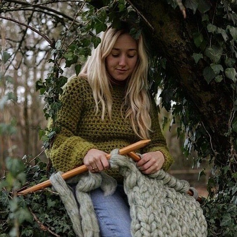 Photo of Sophie Hale sat under a tree with Ivy knitting a large blanket