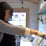 Artist Jessica Stroud holds and examines her glass art in a workshop.