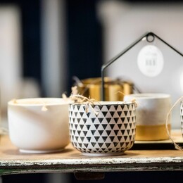 A wooden table/tray with decorated mugs on top.