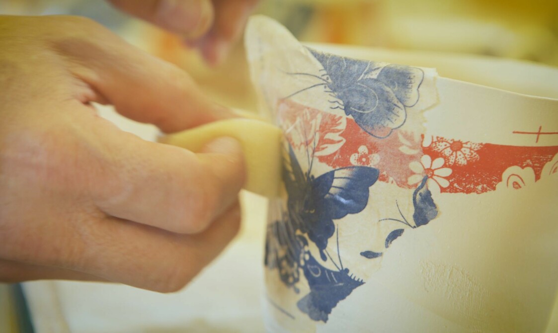A pair of hand printing butterflies on to pottery