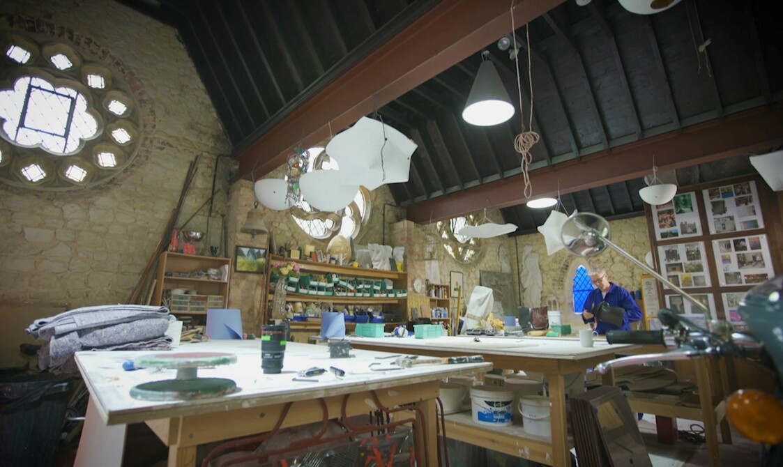 A large art studio with various materials and two tables