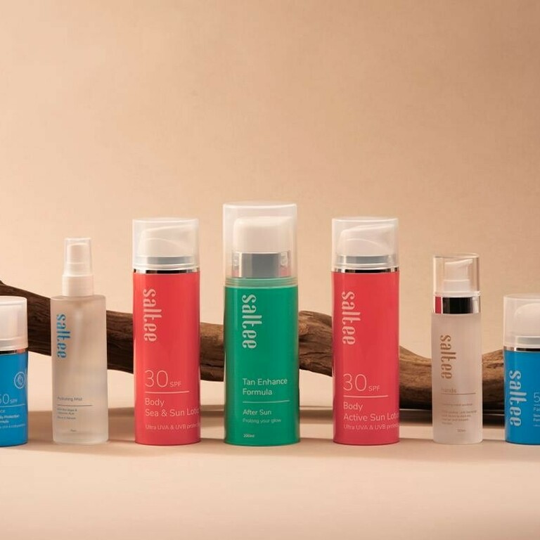 A display with a large piece of driftwood behind a selection of 'Saltee' skin products