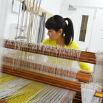 Nao Fukumoto using a weaving machine in a farnham maltings studio.
