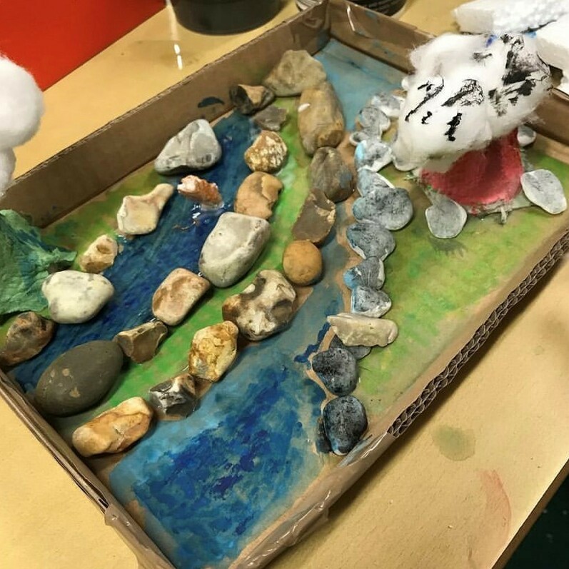 A photo of a landscape that has been created using recycled materials to recreate mountains and rocks and the ocean
