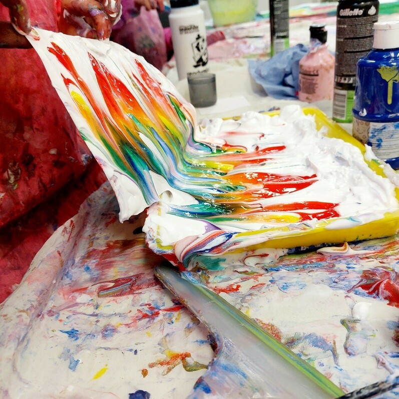 A photo of young children making paintings
