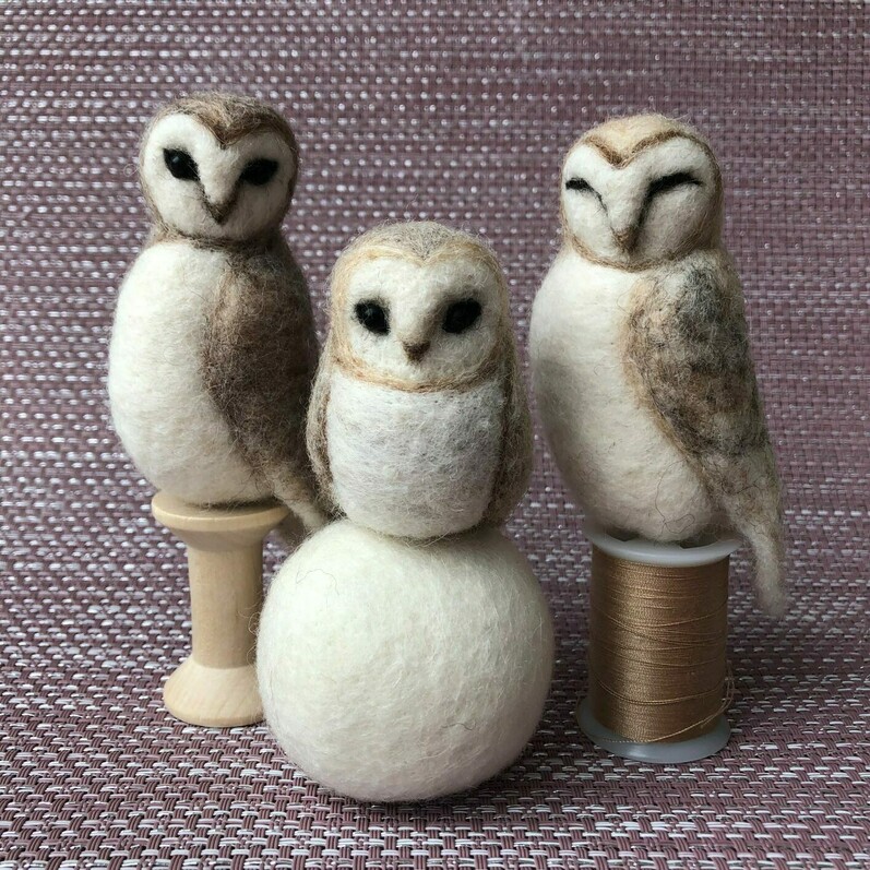 Three needle felted owls sat on thread and a snowball