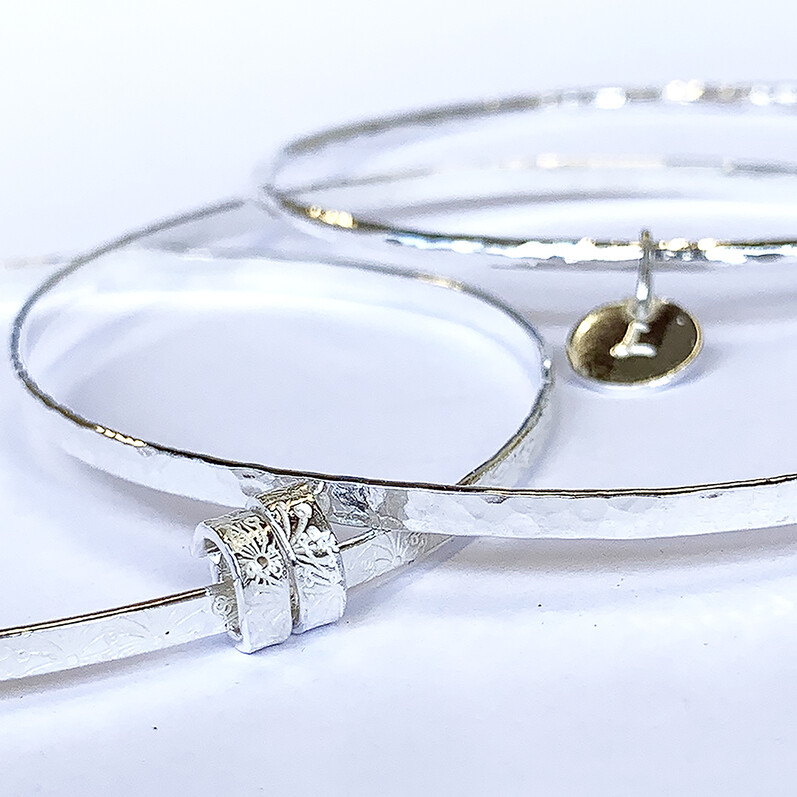 A couple of silver bangles with charms
