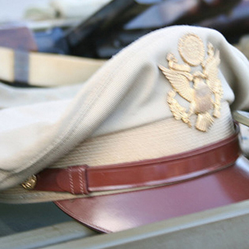 A brown and green military hat resting on a brown surface