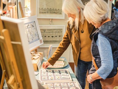 Two woman browse a craft stall at the festival of Crafts