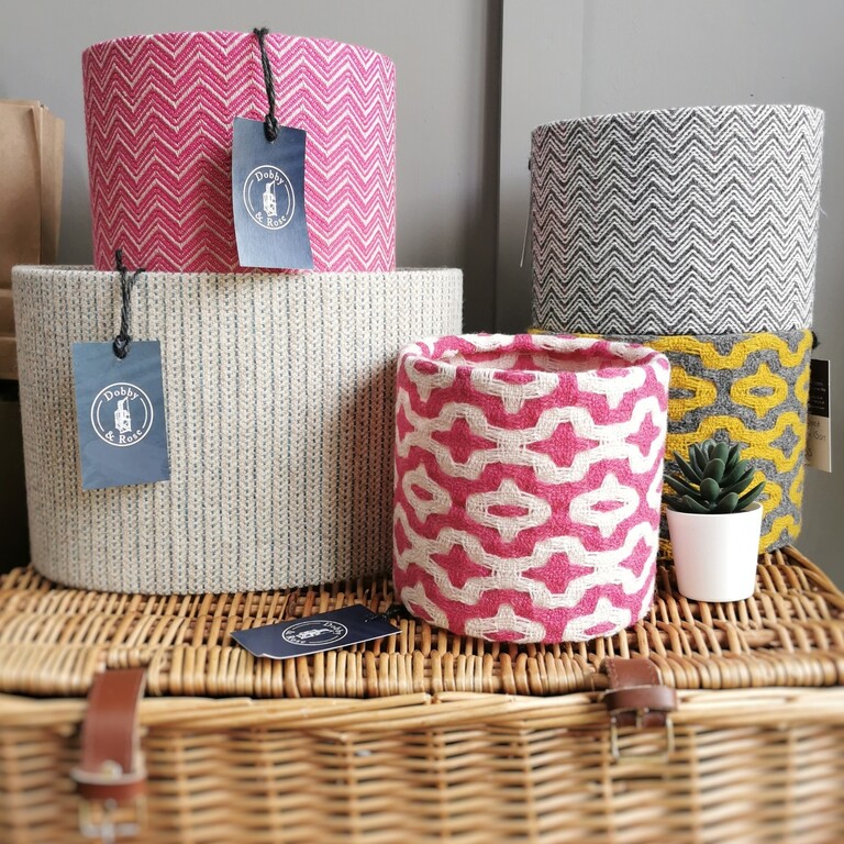 A stack of pink and white handwoven lampshades