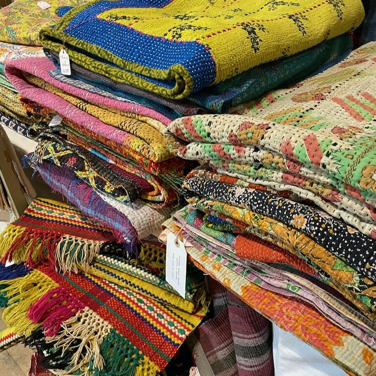 pile of vintage kantha quilts folded