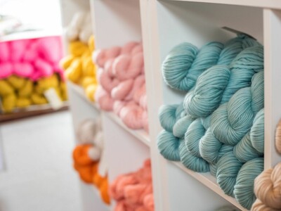 A row of shelves filled with different colours of wool.