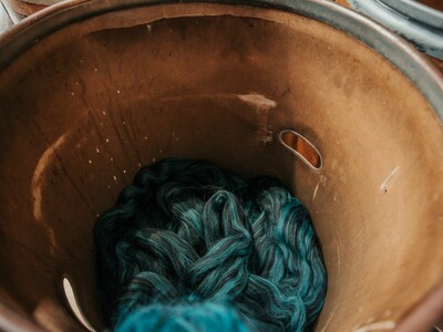 A metal drum full of blue thread/wool.