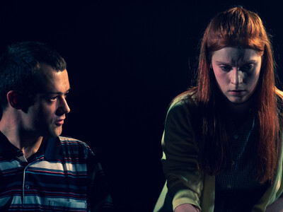 Man and women deep in thought against a dark background
