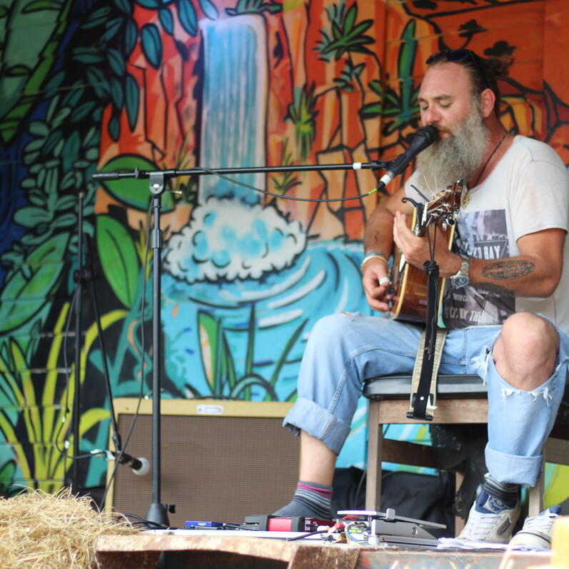 Man playing guitar and singing into a microphone