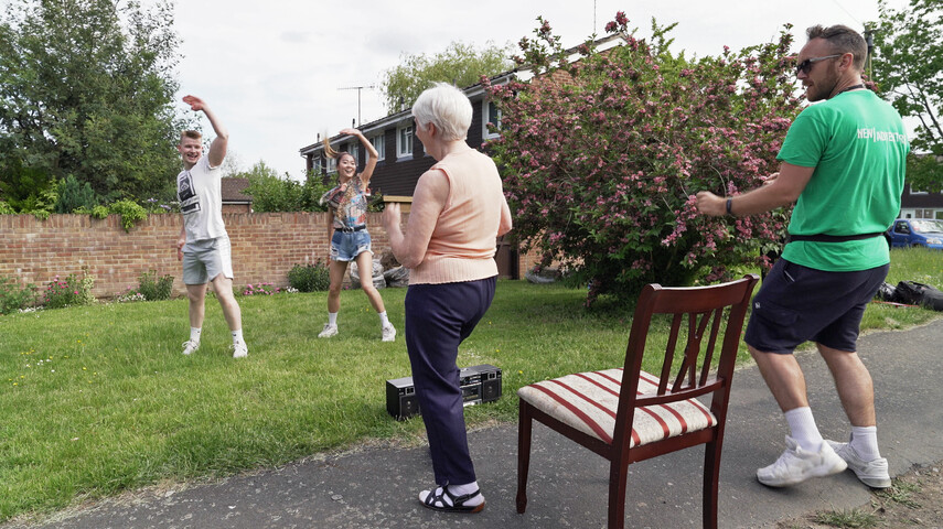 Two dancers from Doorstep Duet perform in-front of an elderly lady.
