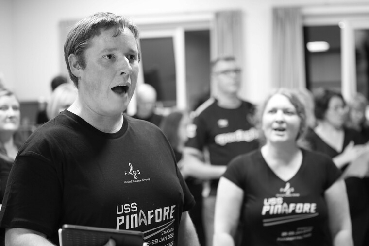 Musical theatre group member Kevin Sampson singing with other group members.