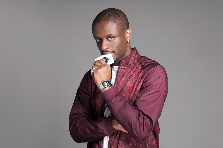 Promotion shot of magician Magical Bones holding a card towards his mouth