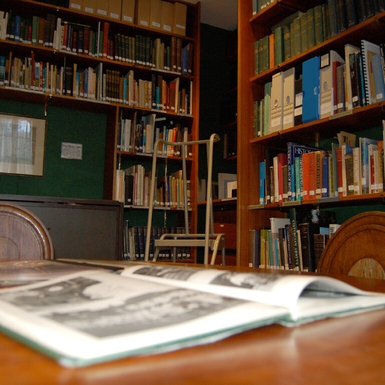 A view of a wooden table and an open book inside a library