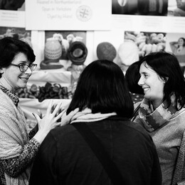 Shot of three people talking in the festival marketplace, in black and white