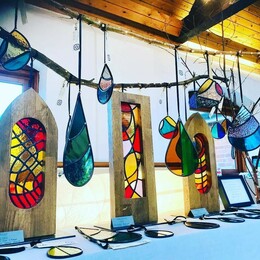 A table display of a number of glass mosaic decorations.