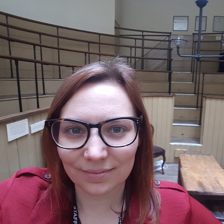 A woman smiles at the camera in a theatre room