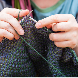 a woman's hands knitting