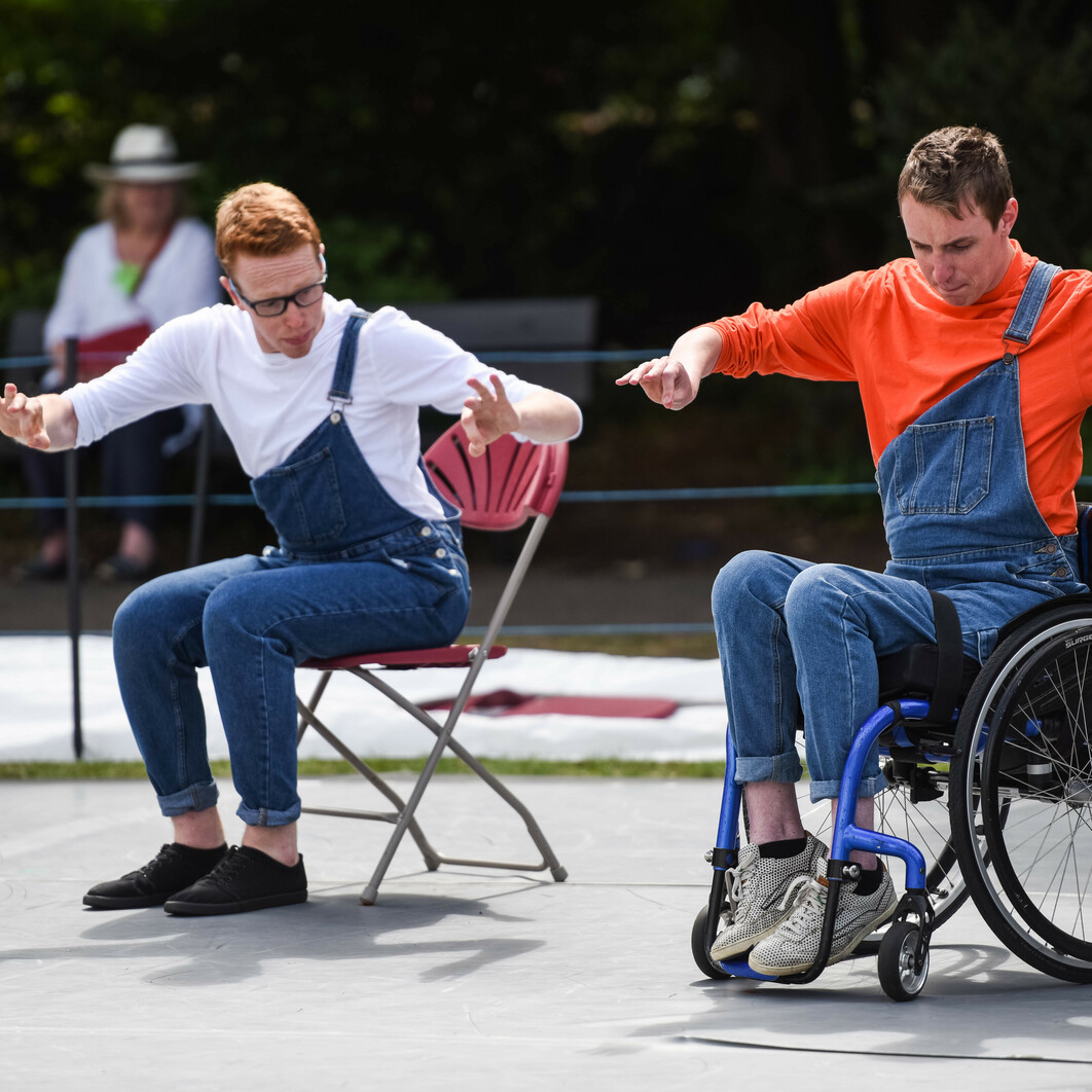 A man using a wheelchair and a man in a seat dance on stage in farnham gostrey meadows.