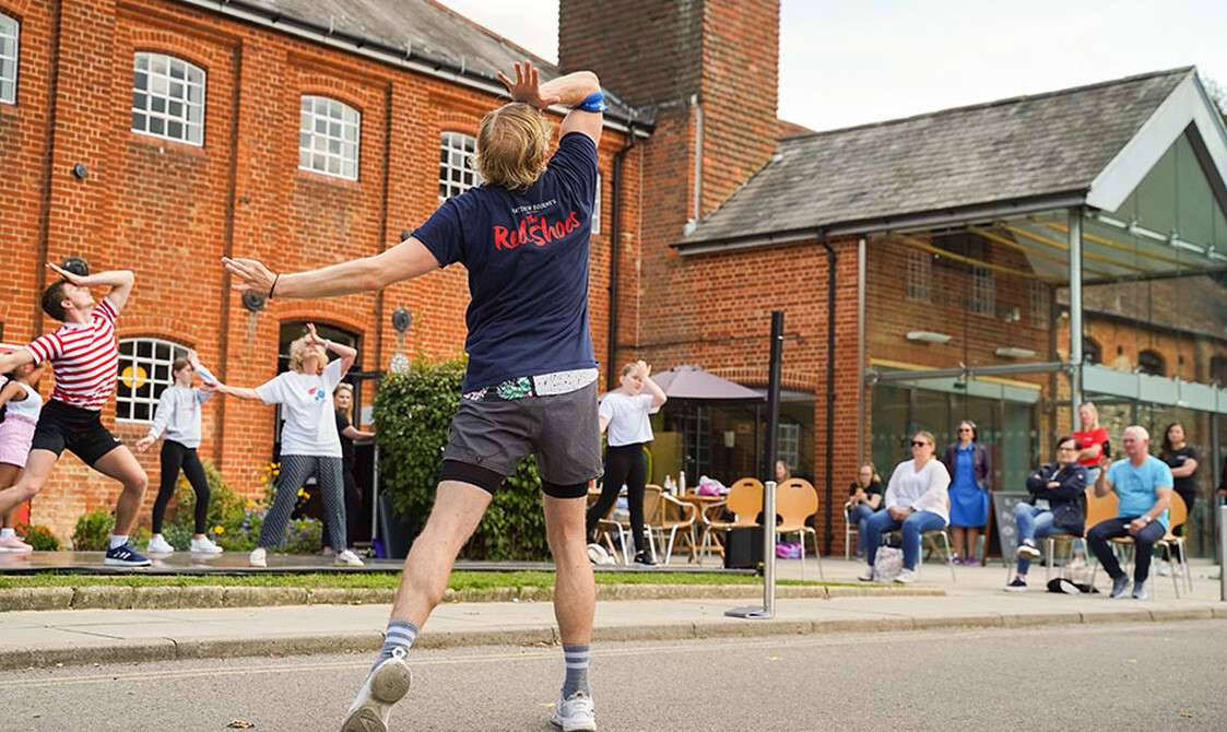 A group dancing outside the front of farnham maltings