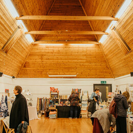People looking round an event in Double story wooden beamed room