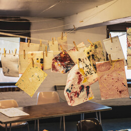selection of colorful Prints hanging up to dry in the East Wing Workshop