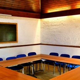Tables joined to form a rectangle around a room with chairs