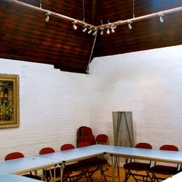 Sun Lit Room with Tables In a rectangle and chairs tucked under