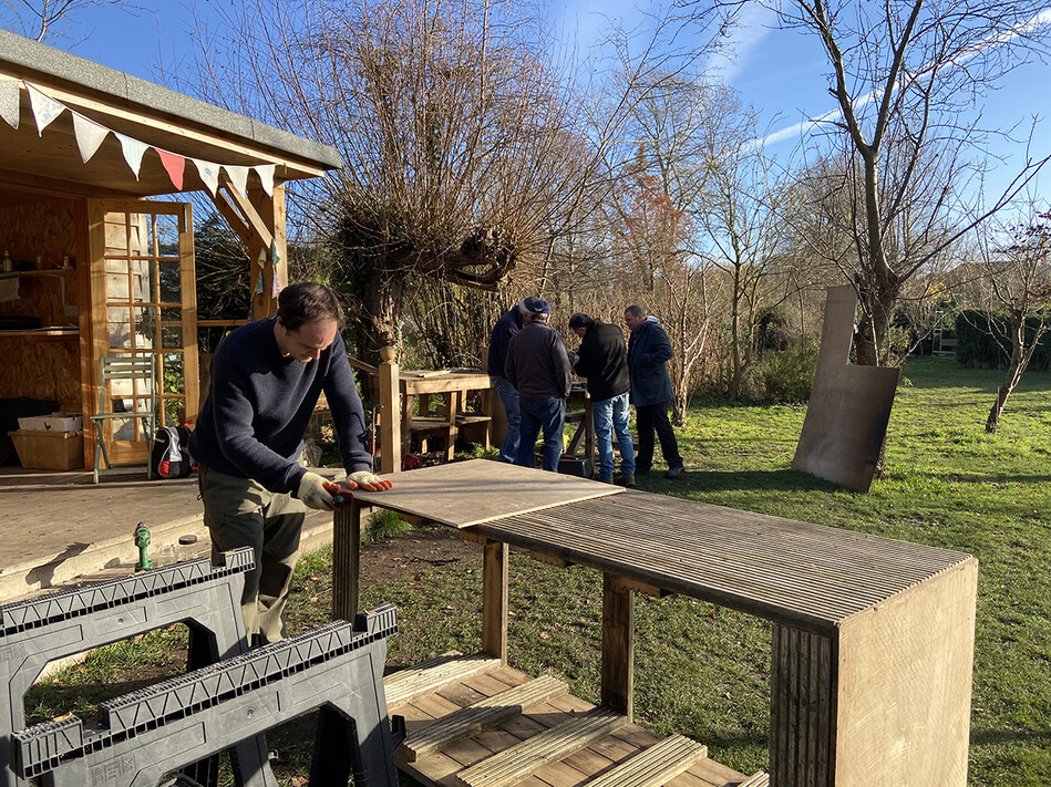 Member of Men in Sheds group working on wooden panel